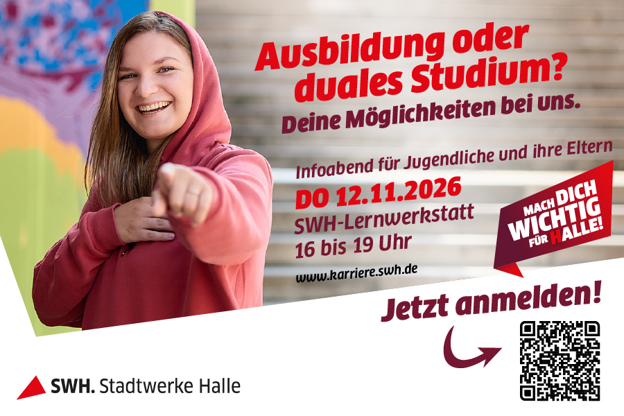 Ein Mädchen im roten Pullover zeigt lächelnd in die Kamera.