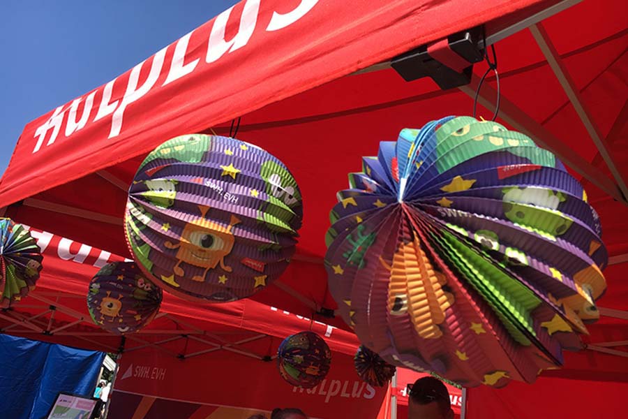Bunte Lampions hängen an einem Zelt. 