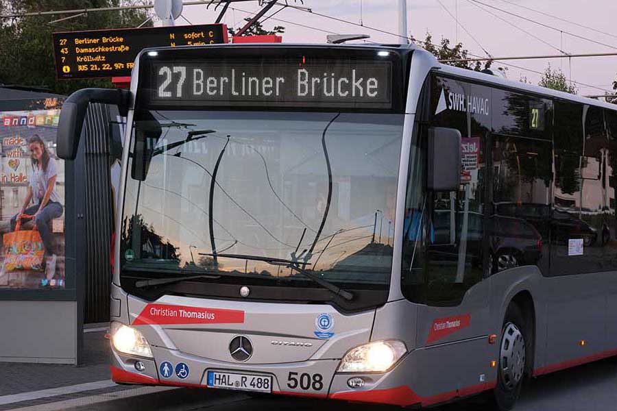 Die Buslinie mit der Zielanzeige '27 Berliner Brücke' steht bei Dämmerung an einer Haltestelle.