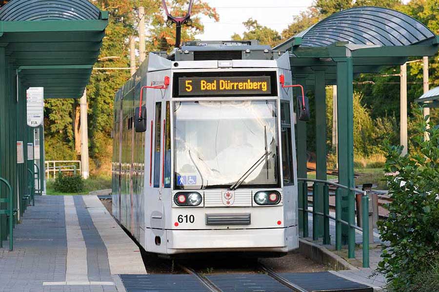 Straßenbahn der Linie 5 mit Zielanzeige 'Bad Dürrenberg' an einer Haltestelle im Grüne.