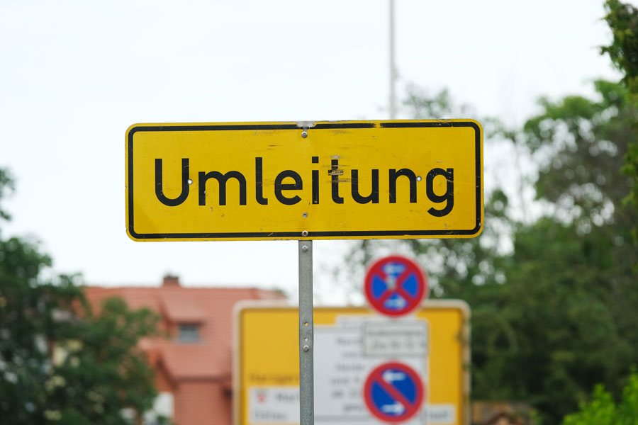 gelbes Straßenschild mit der schwarzen Aufschrift Umleitung 