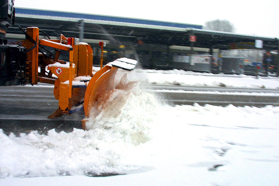 Ein Schneeschieber schiebt Schnee.