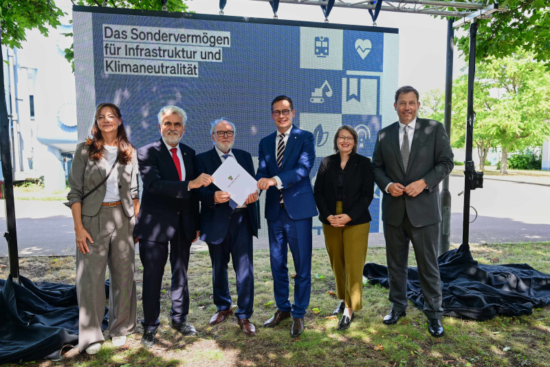 Sechs Menschen stehen am Wasserwerk Beesen, darunter Bundesfinanzminister Lars Klingbeil.