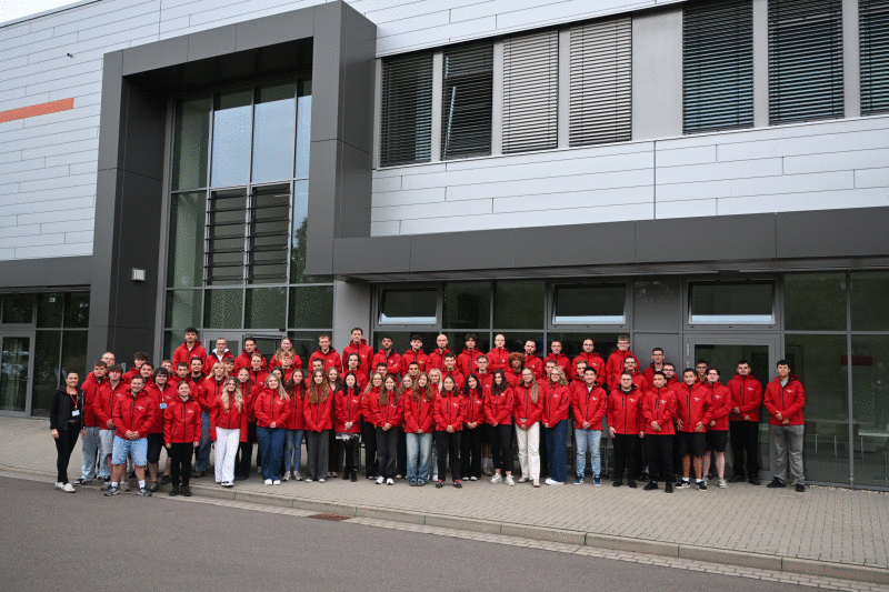 Die neuen Auszubildenden und dual Studierenden stehen an der Lernwerkstatt der Stadtwerke Halle. 