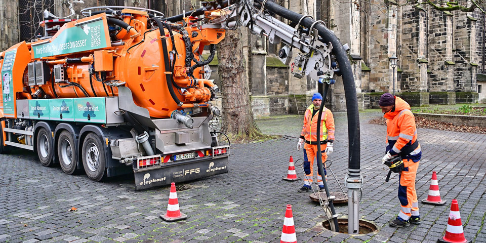 Mitarbeiter arbeiten mit dem Spülfahrzeug.