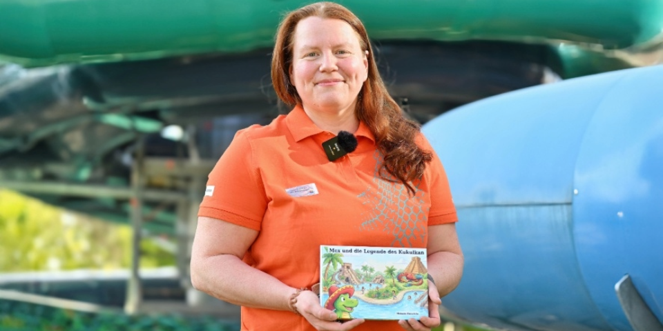 Melanie Heinrichs steht mit dem Kinderbuch vor Rutschen.