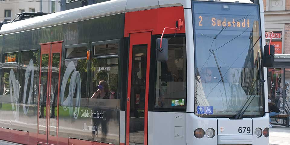 Straßenbahn der Linie 2 mit Zielanzeige 'Südstadt' in roter und weißer Lackierung auf einer Stadtstraße.