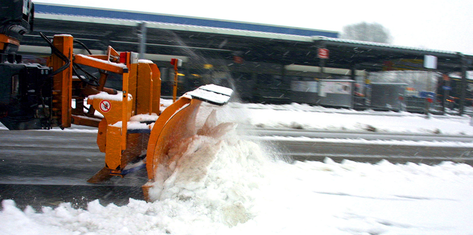 Ein Schneeschieber schiebt Schnee.