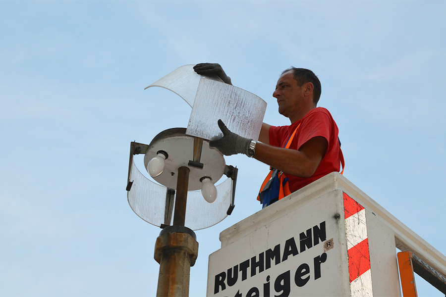 Mitarbeiter tauscht Lampe aus.
