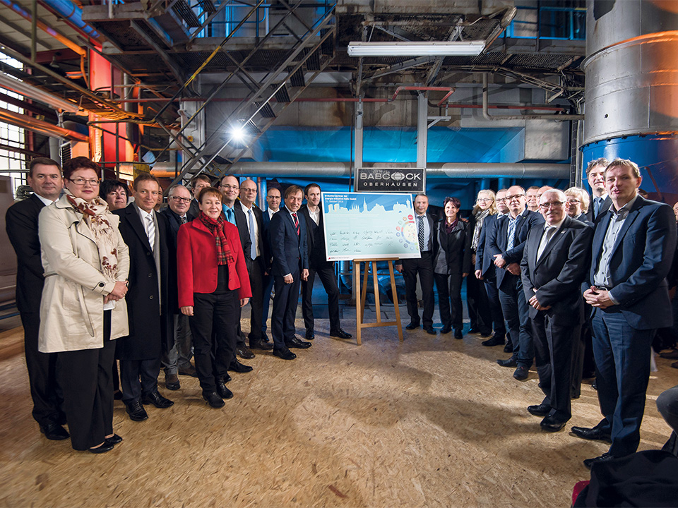 Die Mitglieder der Energie-Initiative stehen im Kraftwerk in einem Halbekreis.