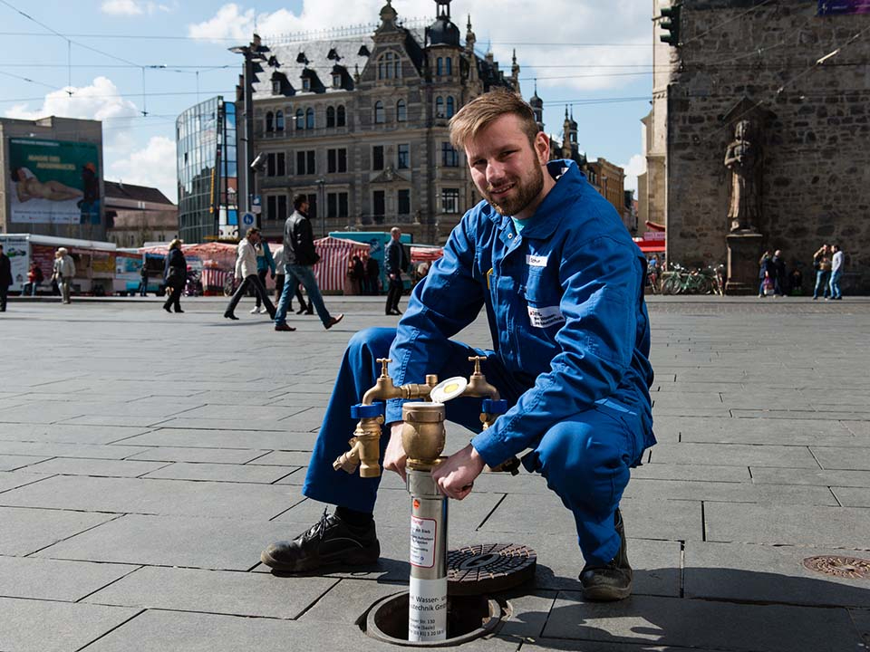 Mitarbeiter montiert Standrohr auf dem Marktplatz.