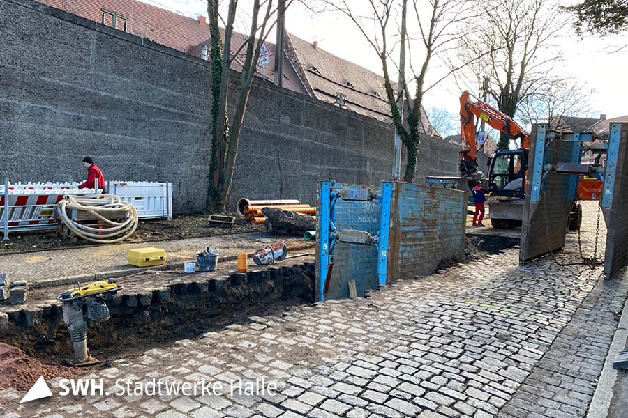 Tiefbauarbeiten mit einem Bagger in einer Straße in Halle.