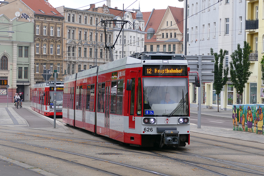 Eine rote Straßenbahn der Linie 12 fährt Richtung Hauptbahnhof. Dahinter wartet eine weitere Bahn an der Haltestelle Steintor.