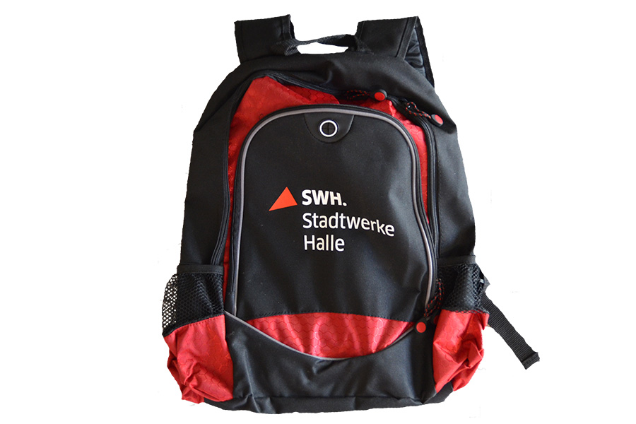 Das Foto zeigt einen schwarz-roten Rucksack mit der weißen Aufschrift "SWH.Stadtwerke Halle".