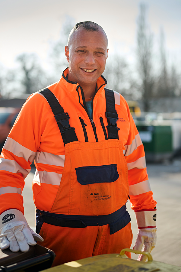 HWS Mitarbeiter Martin Kügler steht auf dem Betriebshof hinter einer gelben Tonne.
