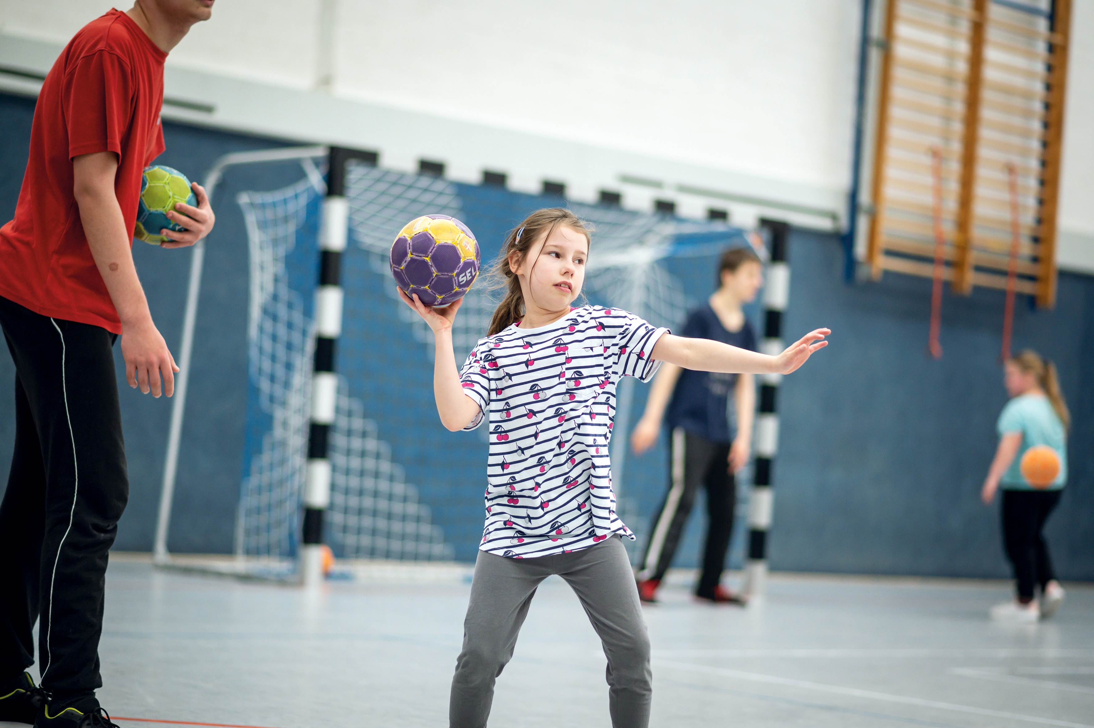 Ein Mädchen spielt Handball.