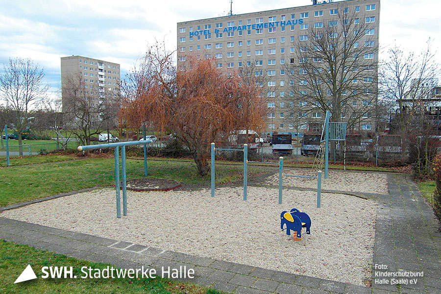 Das Bild zeigt einen in die Jahre gekommenen Spielplatz Im Sand steht ein Gerüst und ein blauer Elefant, der als Spielgerät für kleine Kinder dient.