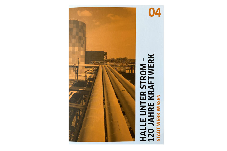 Das Foto zeigt ein weiß-oranges Buchcover mit der Aufschrift "Halle unter Strom - 120 Jahre Kraftwerk".