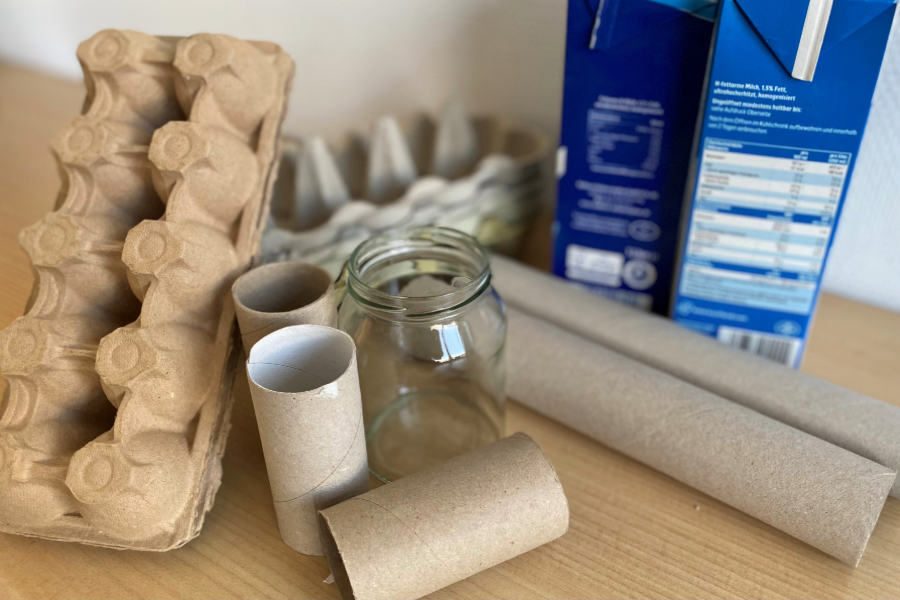 Auf einem Tisch stehen leere Schraubgläser, Eierkartons und Klopapierrollen.