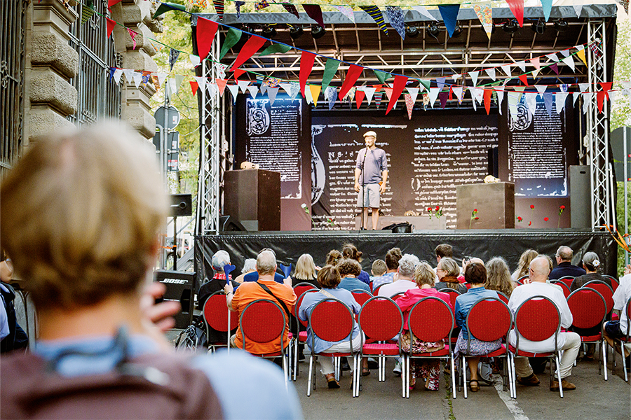 Schaupieler steht vor Publikum auf der Volksbühne