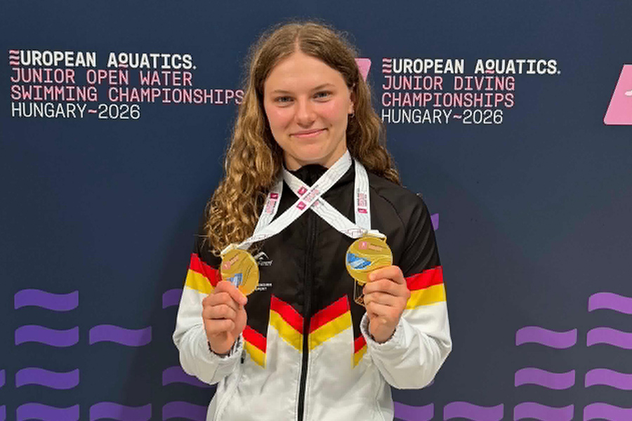 Wasserspringerin Emily Deml trägt ihre zwei Gold-Medaillen um den Hals.