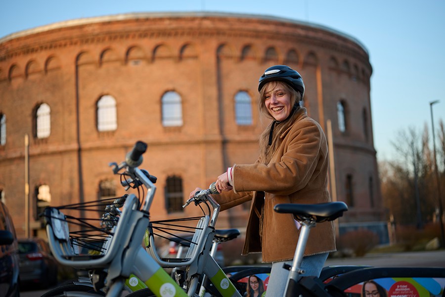 Frau leiht Fahrrad mit App aus.