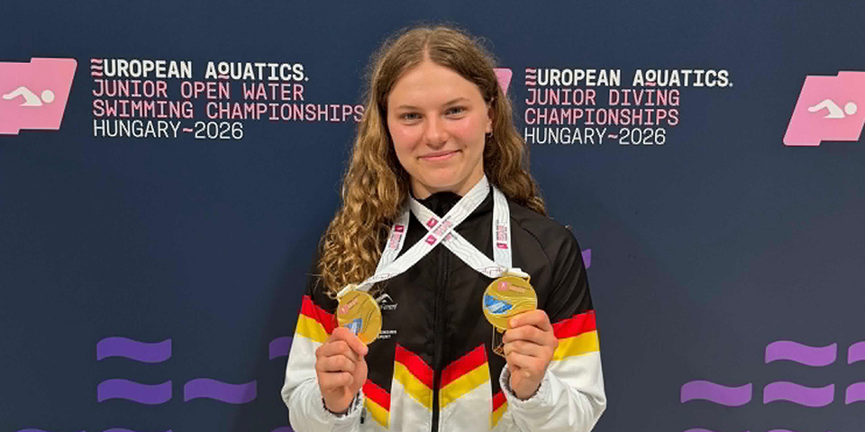 Wasserspringerin Emily Deml trägt ihre zwei Gold-Medaillen um den Hals.