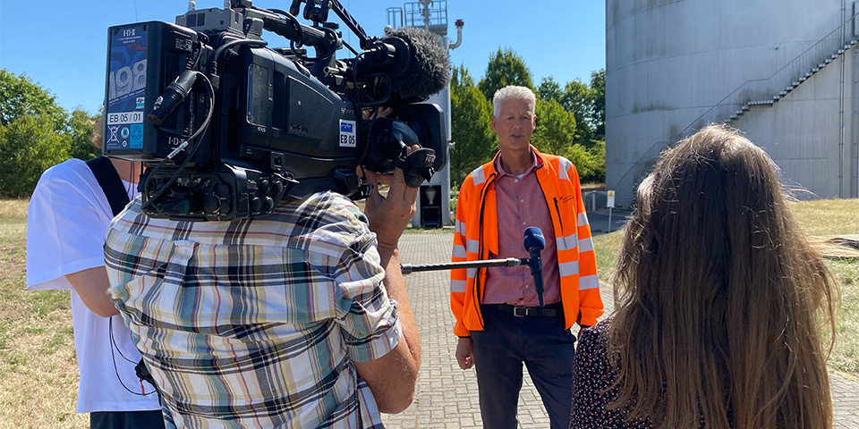 Mitarbeiter der HWS wird von einem Kamerateam interviewt.