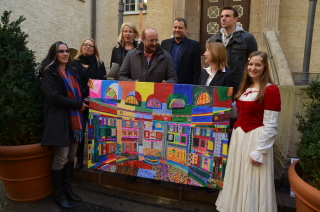 Dornröschen überreicht Ingo Michalak das Bild, das zum 100. Geburtstag des Stadtbades von Schwimmgästen gemalt wurde und das Herr Michalak im Rahmen der Crowdfundingaktion als Dankeschön erhält.