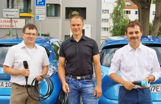 Mitarbeiter der Stadt Halle, Stadtwerke Halle und teilAuto vor zwei E-Autos