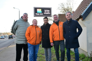 Vertreterinnen und Vertreter des Projekts Smart City Halle stehen vor der neuen Verkehrsinfotafeln.